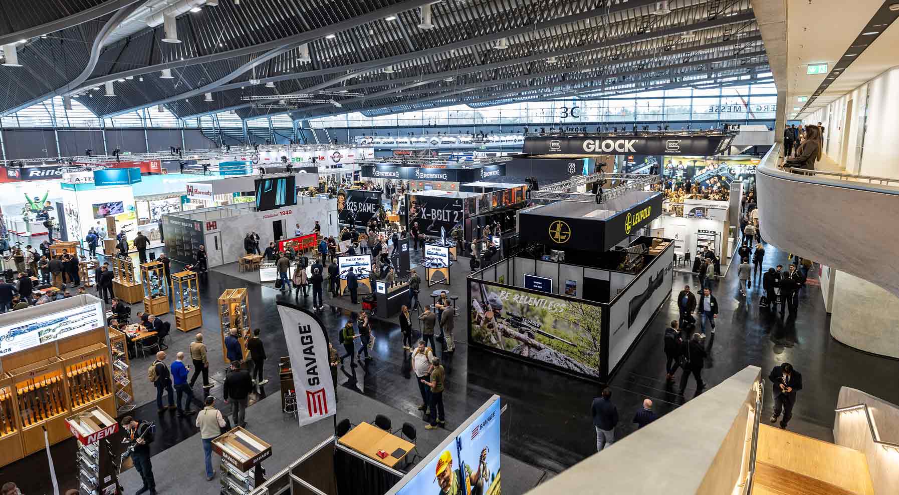 Blick von oben in die Messehalle 3C der IWA OutdoorClassics mit zahlreichen Ausstellungsständen. Viele Besucher bewegen sich durch die weitläufige Halle.